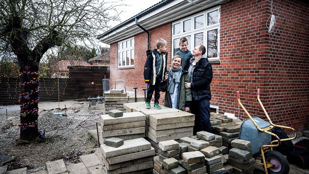 Familie står udenfor hus med byggeprojekt